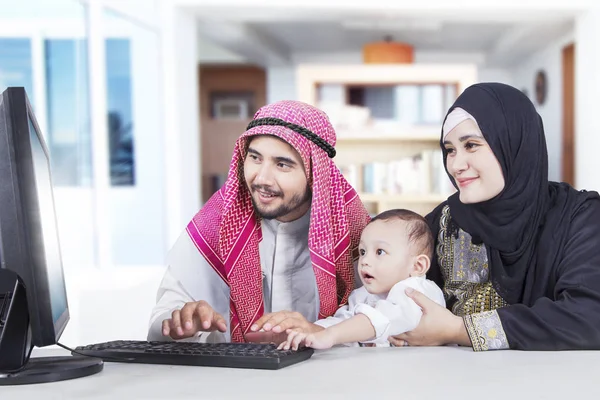 Muslim family using a computer together at home