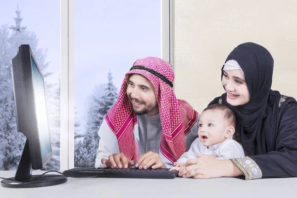 Muslim family using computer in winter season