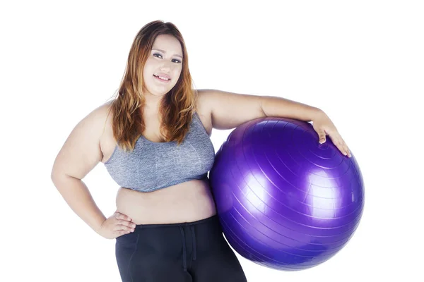 Nadwagę kobieta trzymając piłkę fioletowy — Zdjęcie stockowe