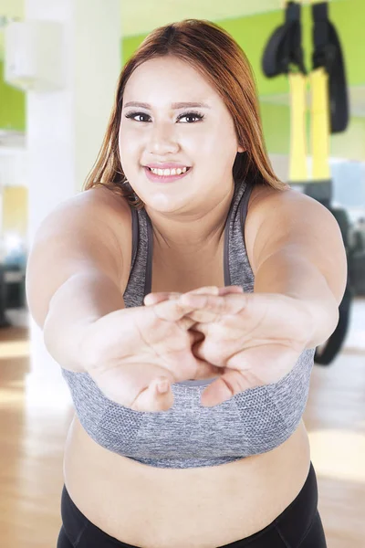 Mujer con sobrepeso estirándose en el gimnasio — Foto de Stock