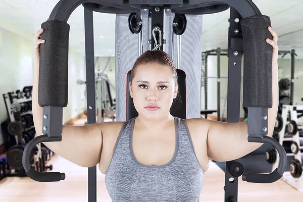 Kobieta z ramienia naciśnij maszyny w centrum fitness — Zdjęcie stockowe