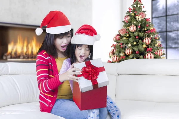 Giovane madre e bambina sorpresa dal regalo — Foto Stock