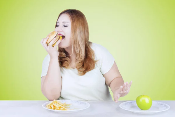 Hamburger yeme kilolu sarışın kadın — Stok fotoğraf