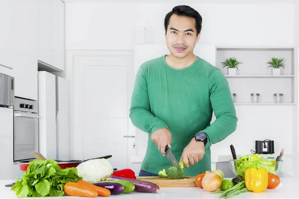 Человек делает салат на кухне — стоковое фото
