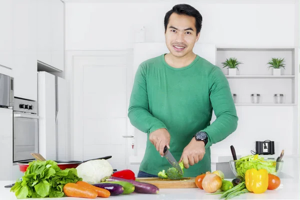 Man skär broccoli i styrelsen — Stockfoto