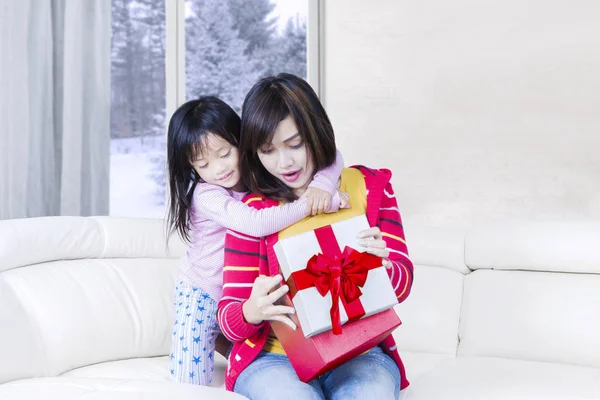 Счастливая женщина и ее ребенок открывают подарок — стоковое фото