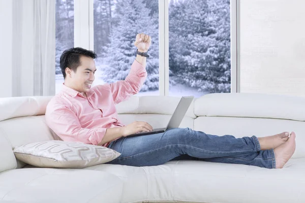 Bonito homem levantando a mão no sofá — Fotografia de Stock