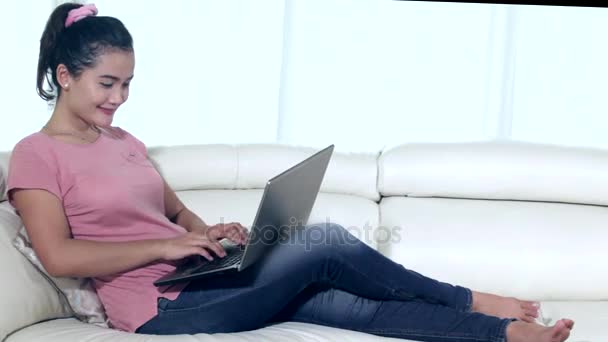 Mulher asiática usando laptop no sofá — Vídeo de Stock