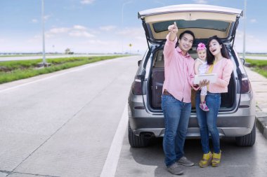 Sokakta araba arkasında aile duran