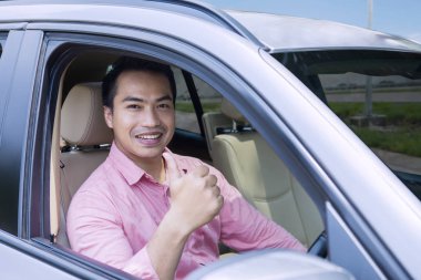 Genç erkek arabaya başparmak gösterilmesini