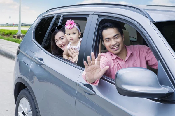 Азиатская семья смотрит в окно в машине — стоковое фото