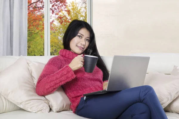 Mulher asiática detém café quente e laptop — Fotografia de Stock