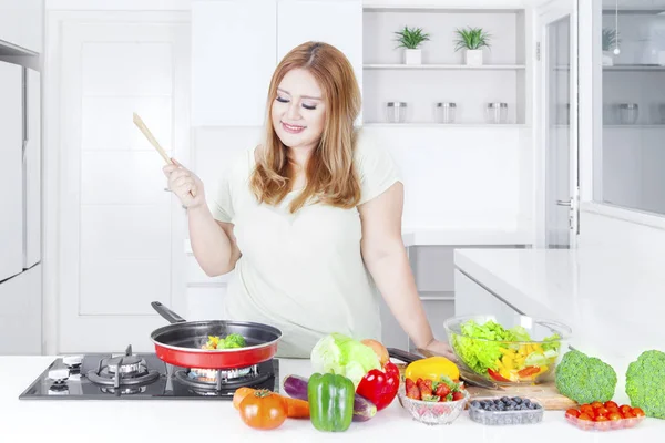 Blond kvinna matlagning grönsaker — Stockfoto
