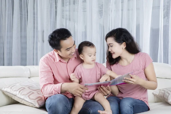 Cheerful family is reading book at home — Stock Photo, Image
