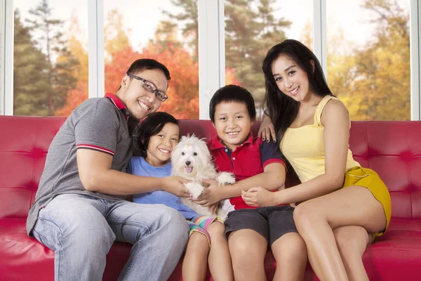 Весела сім'я з цуценям на дивані — стокове фото