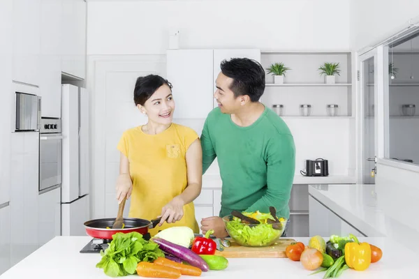 Casal cozinhar legumes na cozinha — Fotografia de Stock