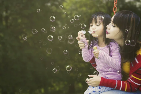 Anne ve kızı sabun balonları patlat — Stok fotoğraf