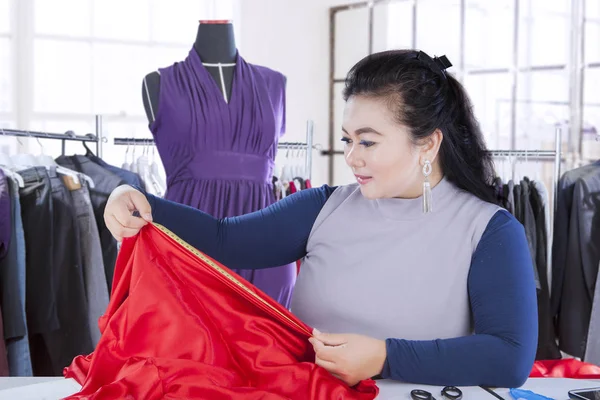Modedesigner mäta tyg på arbetsplatsen — Stockfoto