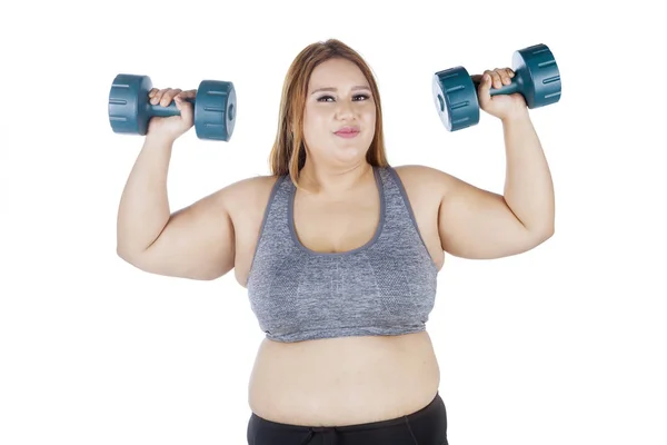 Übergewichtige Frau hebt Hantel in den Händen — Stockfoto