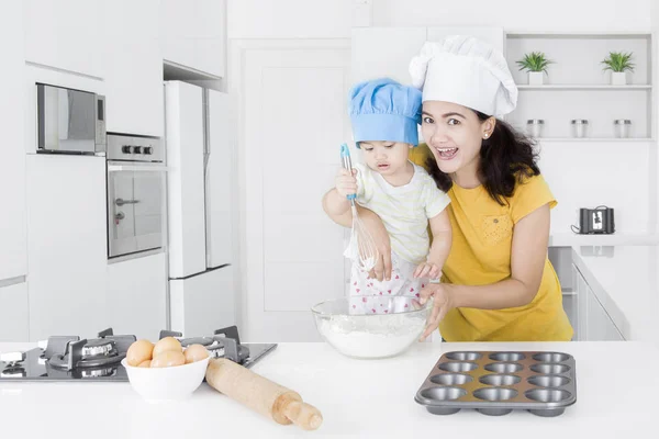 Kvinna och hennes dotter gör tårta — Stockfoto