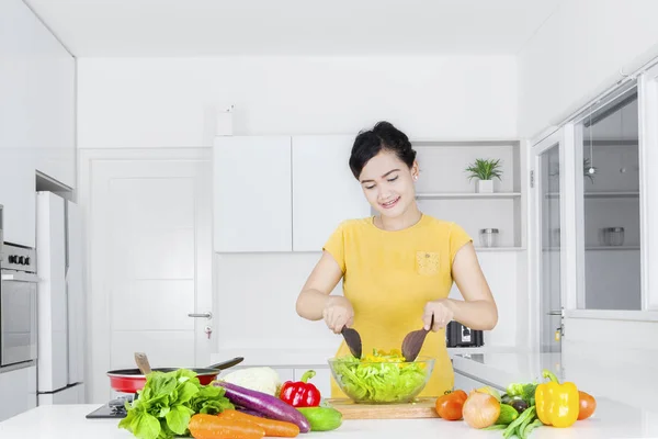 Frau kocht Gemüse und Salat — Stockfoto