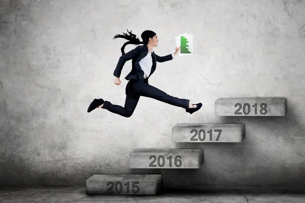 Woman jumping on stairs with financial chart — Stock Photo, Image