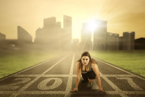 Woman ready to run on start line — Stock Photo, Image