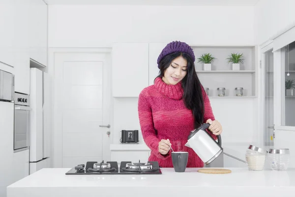 Jovem mulher derramando café na cozinha — Fotografia de Stock