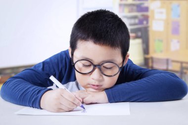 Sınıfta çizim gözlüklü çocuk