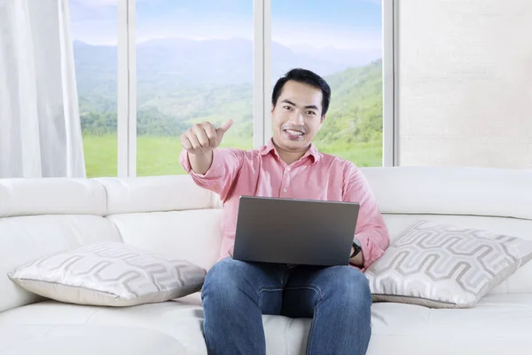 Asiático homem usa laptop na sala de estar — Fotografia de Stock