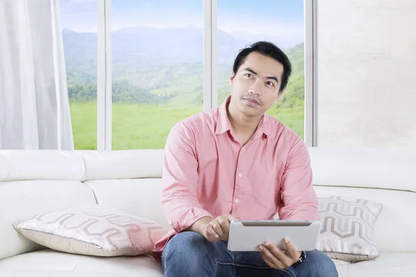 Homem asiático usando tablet no sofá — Fotografia de Stock