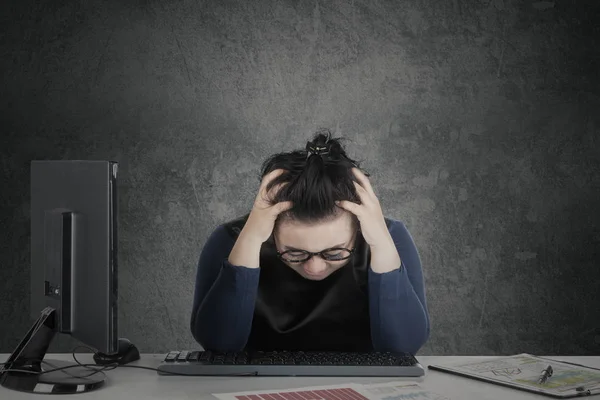 Zakenvrouw houdt haar hoofd op Bureau — Stockfoto