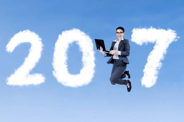 Affärskvinna hoppning med laptop och 2017 — Stockfoto