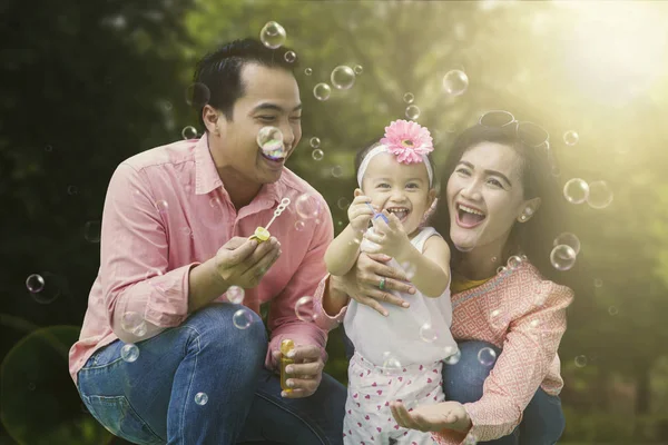 Vrolijke familie spelen met zeepbellen — Stockfoto