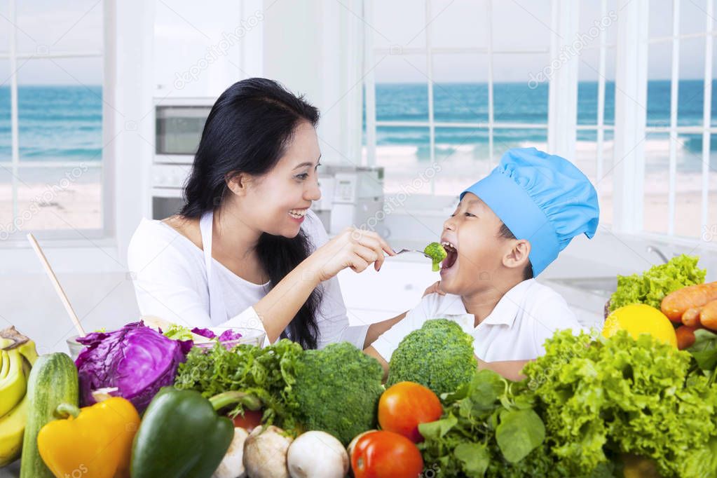 Asian woman gives her son healthy food