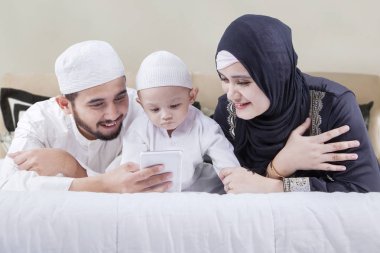 Müslüman aile smartphone ile yatakta yatarken 