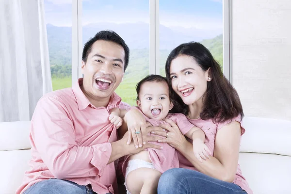 Família relaxando no sofá e rindo juntos — Fotografia de Stock