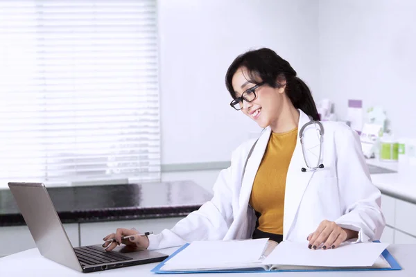 Ärztin tippt auf Laptop — Stockfoto