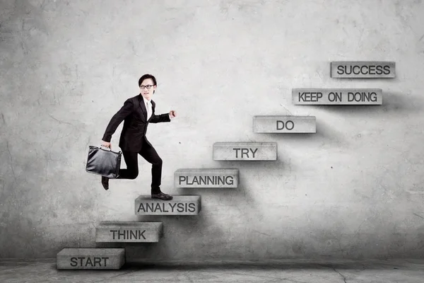 Male entrepreneur steps on stairs with analysis text — Stock Photo, Image