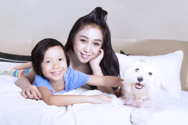 Madre e figlia rilassarsi con cucciolo a casa — Foto Stock
