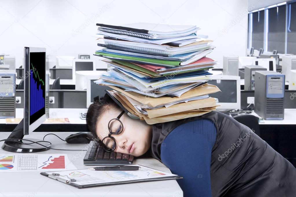 Entrepreneur sleeps on desk with documents 