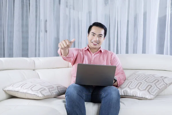 Young man with laptop shows OK gesture — Stock Photo, Image