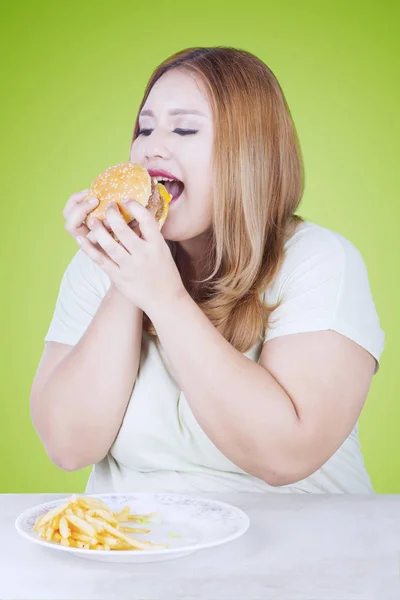 Piękna Blondynka kobieta zje hamburgera — Zdjęcie stockowe