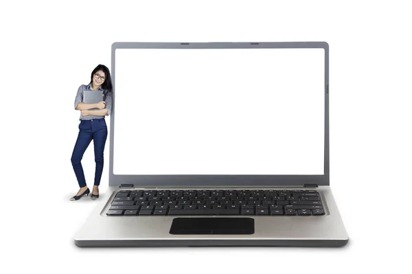Affärskvinna som lutar på stora laptop — Stockfoto