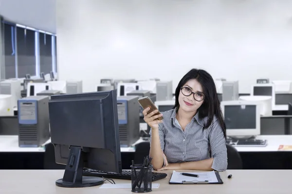 Businesswoman with mobile phone and computer — Stock Photo, Image