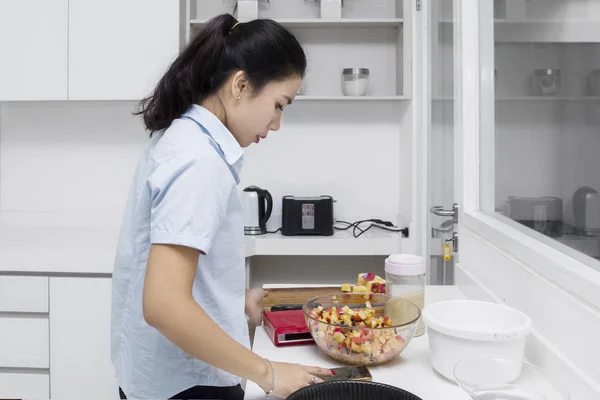 Dona de casa procurando receita no smartphone — Fotografia de Stock