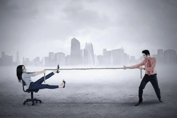 Male entrepreneur pulls his partner with rope — Stock Photo, Image