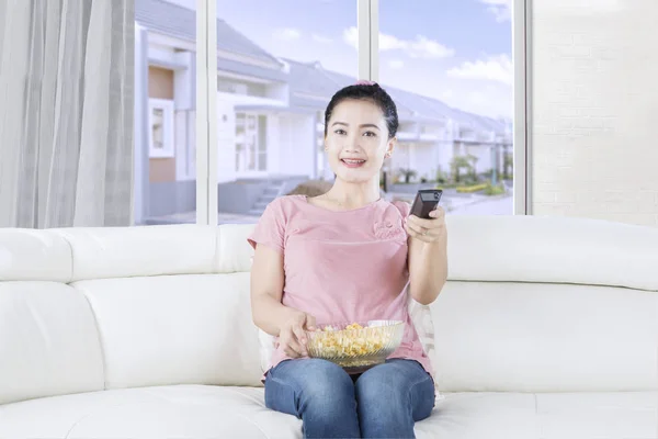 Jolie femme regardant la télévision sur le canapé — Photo