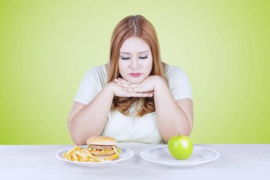 Elma ya da hamburger seçmek kadın düşünüyor