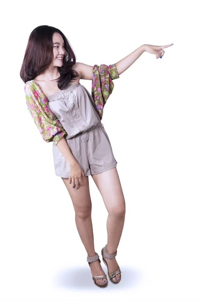 Teenage girl pointing at something on studio — Stock Photo, Image